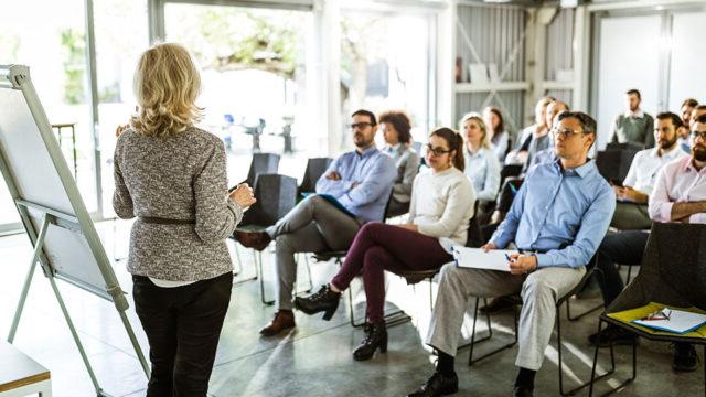 An instructor with a white board presenting to a room of people